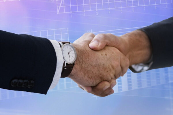 Two arms of people wearing business attire shaking hands in front of a digital themed graphic background - 5 Tips for Using Print and Digital Communications to Build Trust | Why You Need To Plan Your Corporate Holiday Gifts Now