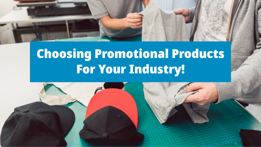 Background of two people analyzing a promotional shirt, with hats also sitting on the table